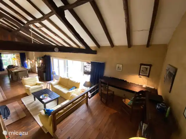 Chez Nous en Francia, Dordoña, Le Buisson-de-Cadouin - casa de campo La sala de estar con sala de estar, mesa de comedor vista desde el otro lado de la habitación. La habitación tiene unos 16 metros de largo. A la derecha la gran terraza en el lado del valle. La foto fue tomada desde una elevación, allí está la estantería y un escritorio, para ser utilizado por 2 personas.