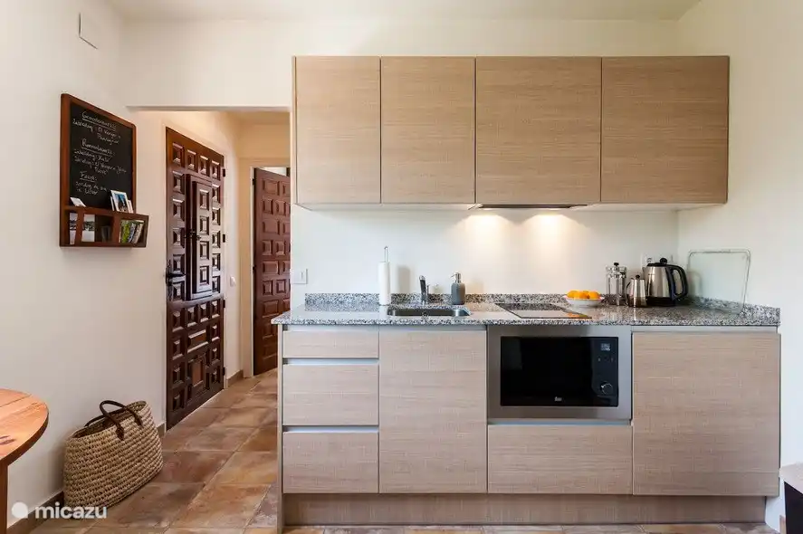 Die voll ausgestattete Küche mit Messern, die geschnitten, Pfannen und ausreichend Weingläsern.