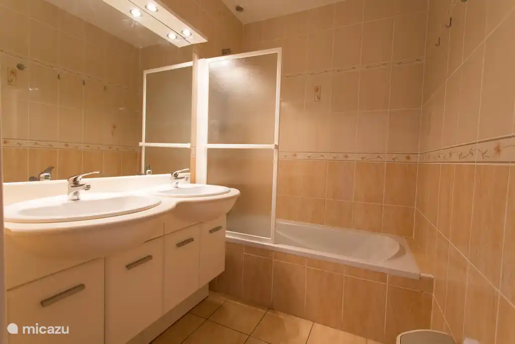 Bathroom with bath and hand shower set. Also washing machine available