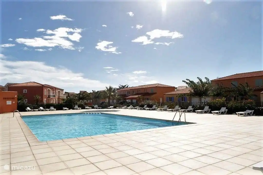 The swimming pool in the park with comfortable sun loungers