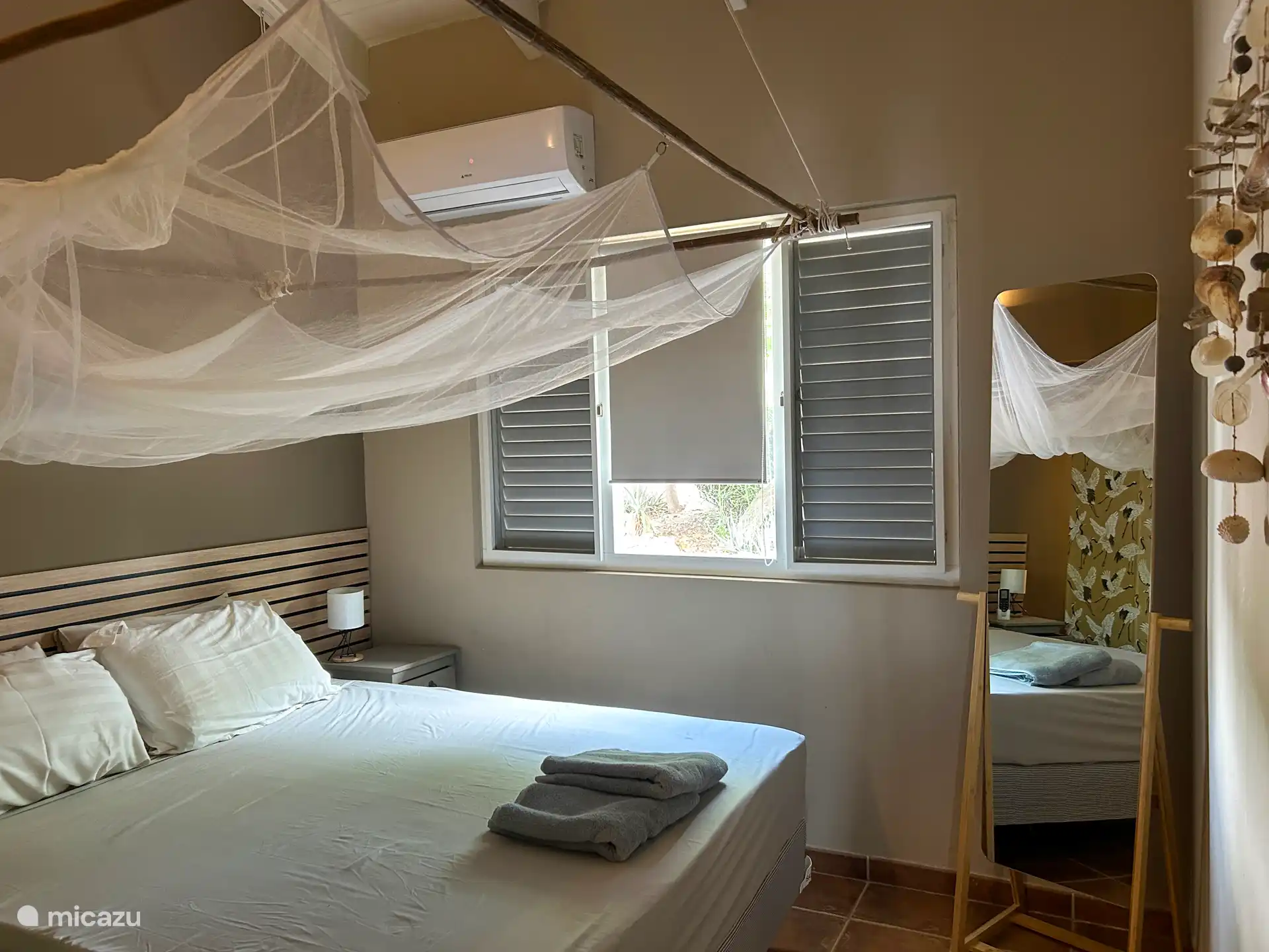 Slaapkamer met klamboe en airco