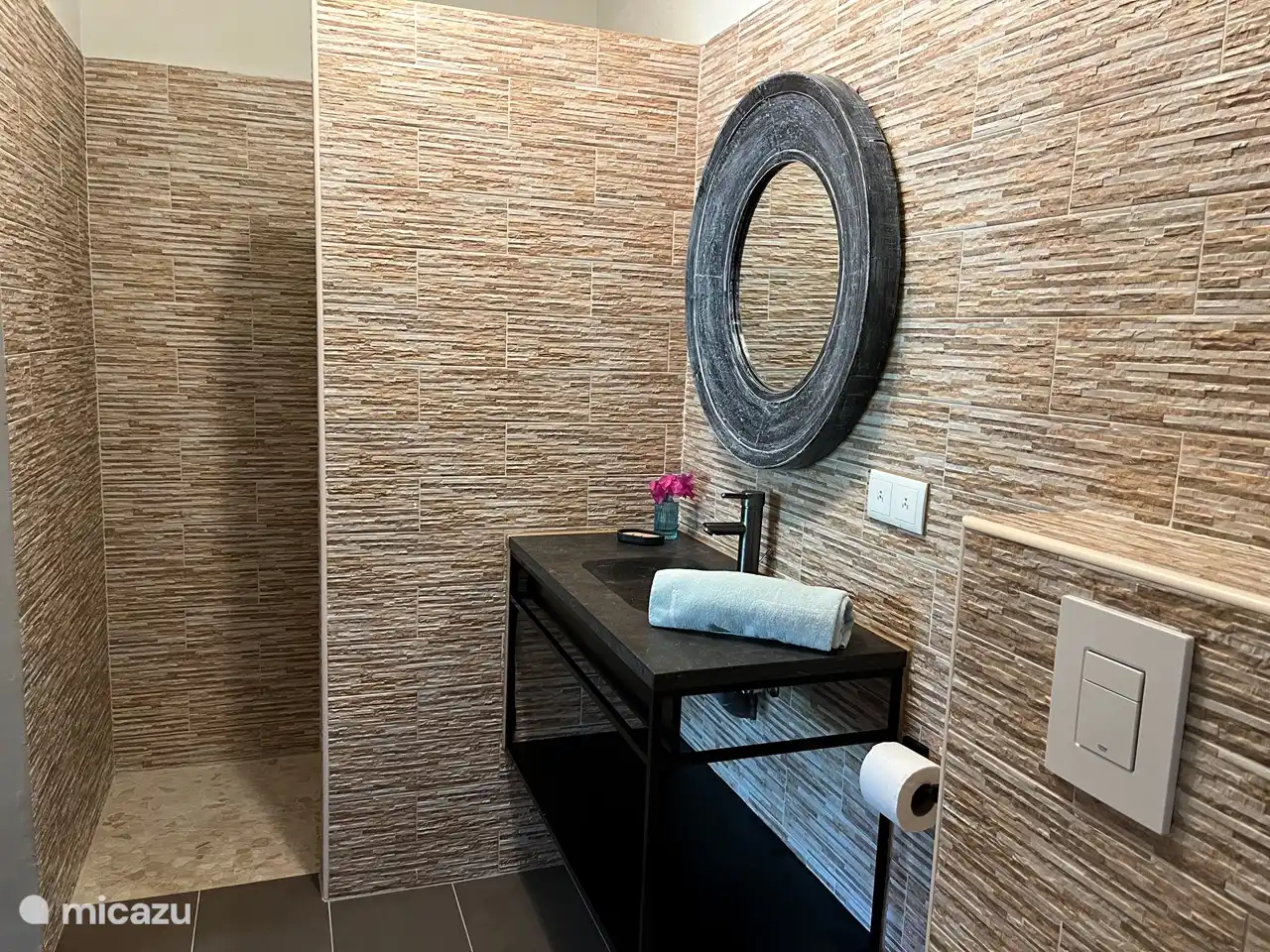 Baño elegante con ducha, lavabo e inodoro.