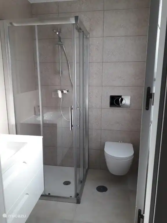 Mooie natuurstenen badkamer met douche.