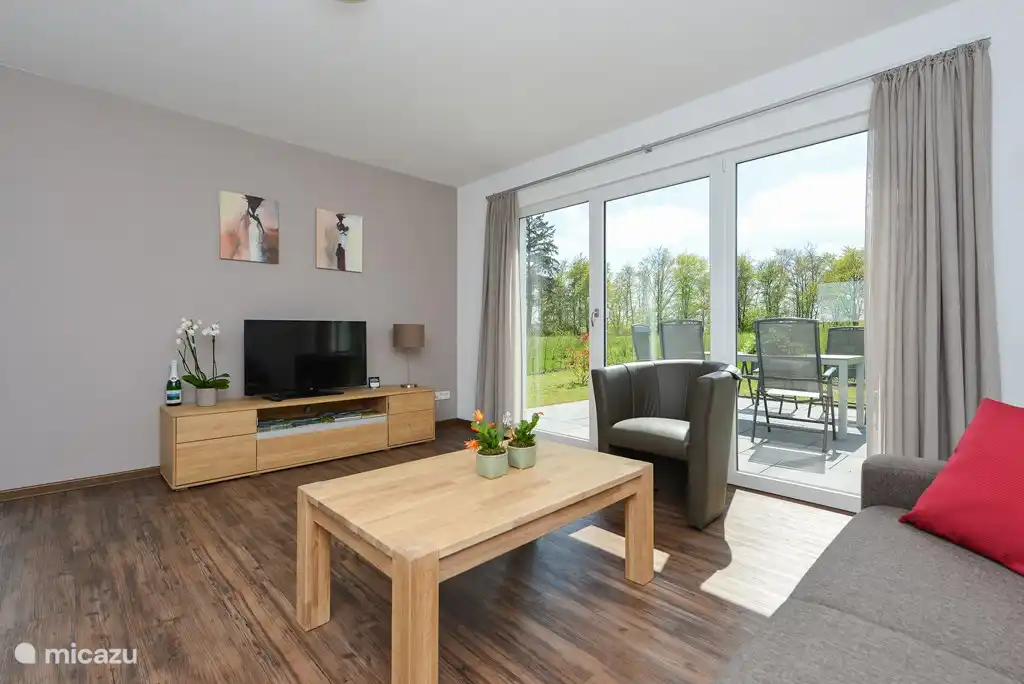 Salon avec portes-fenêtres donnant sur la terrasse privée.