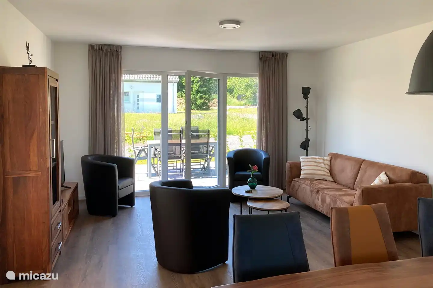 Ambiance chaleureuse dans les maisons de vacances avec portes-fenêtres donnant sur la terrasse privée.