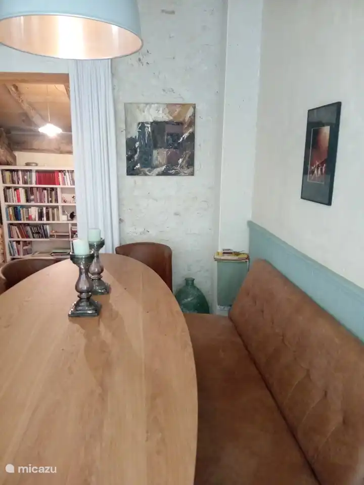 Moderner ovaler großer Esstisch im Wohnzimmer mit Blick auf den Nebenraum mit Bücherregal und Durchgang zur Küche.