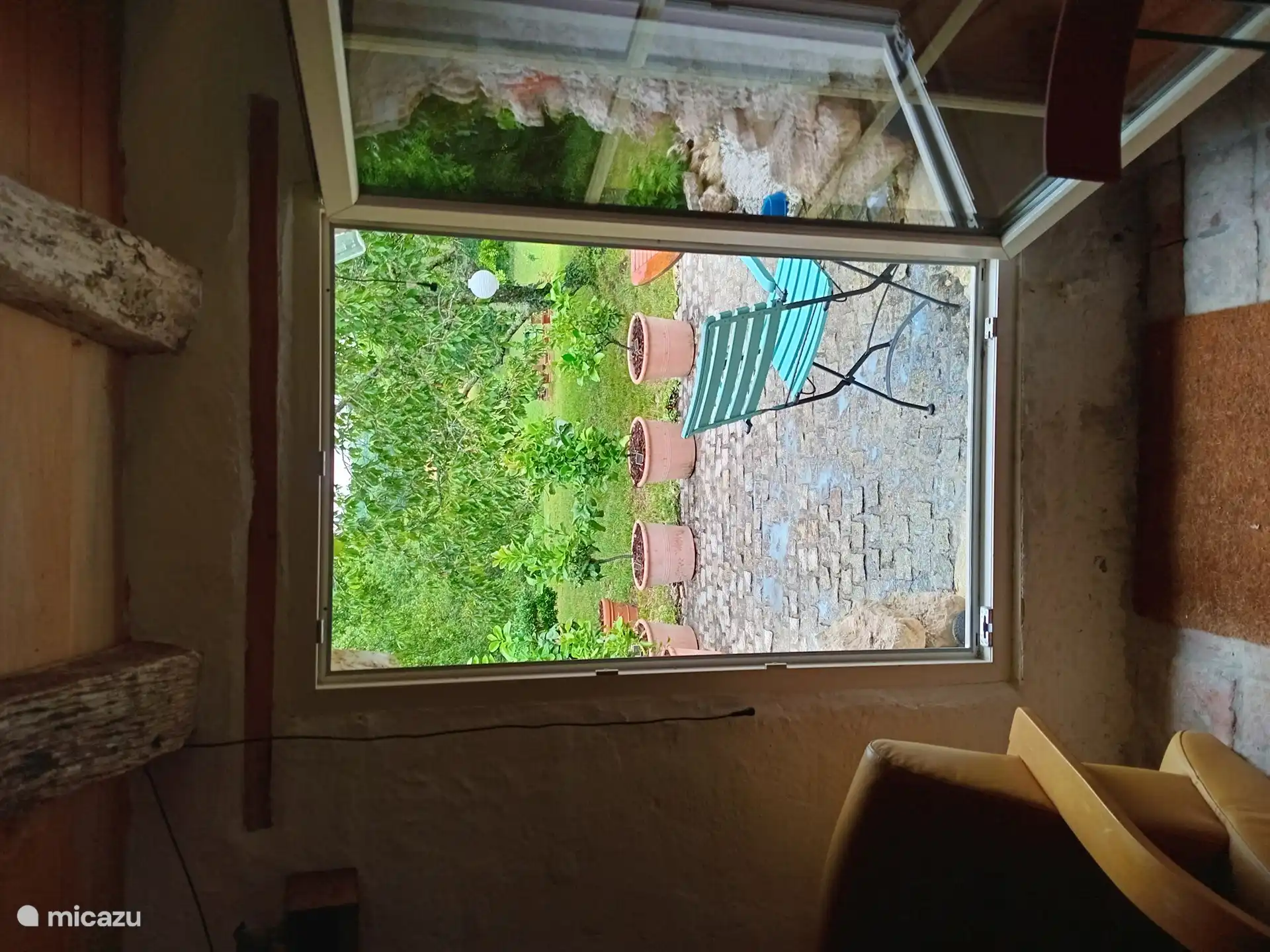 Von der Küche aus gelangen Sie durch ein Durchgangsfenster auf eine Terrasse mit Blick auf den Obstgarten und das Tal hinter dem Haus.