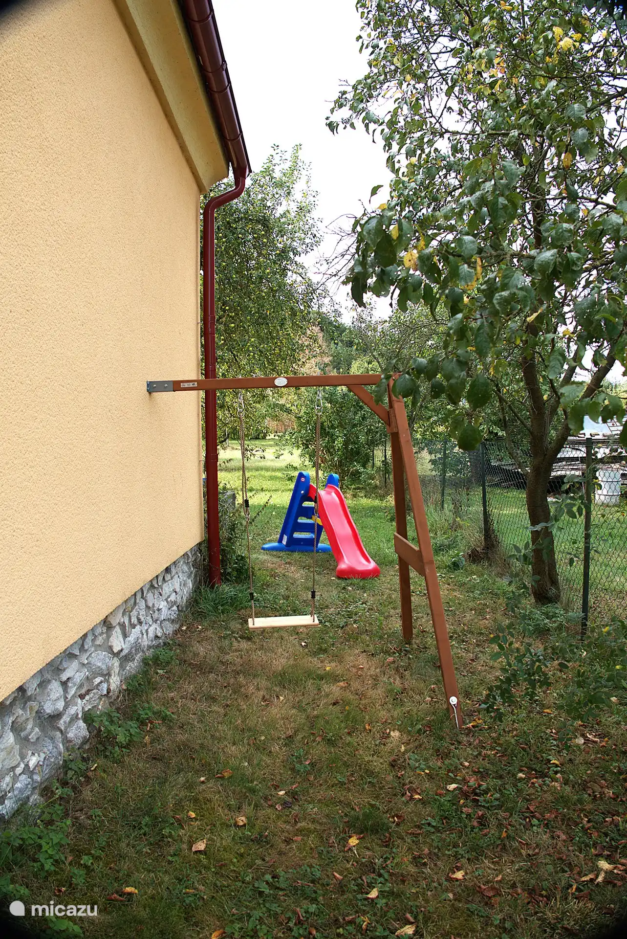 There is a swing and a small slide 