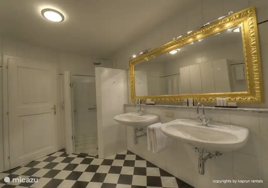 El gran cuarto de baño con bañera, ducha y lavadora.