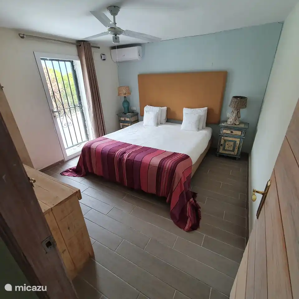 Schlafzimmer mit Kingsize-Bett, Ventilator und Klimaanlage