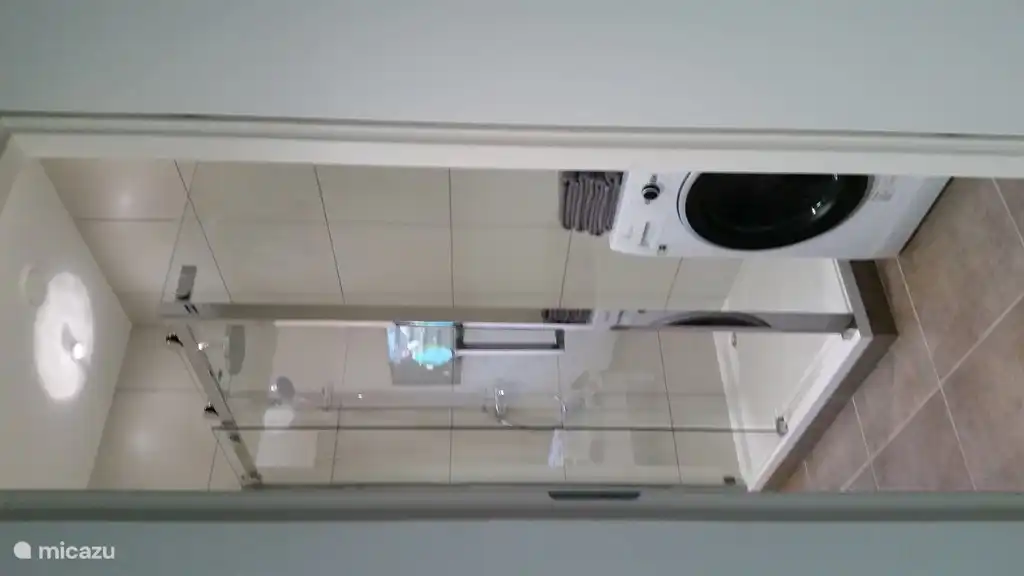 Badezimmer mit Regendusche und Waschmaschine/Trockner-Kombination