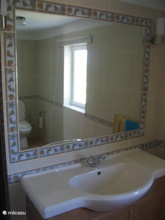 Privé badkamer blauwe slaapkamer met douche, bidet, toilet en wastafel.