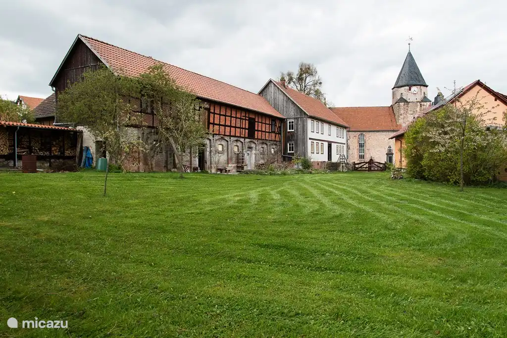 Das Haus mit Scheune vom Garten aus gesehen. Eine große Terrasse, schöne Liegestühle und Sonnenschirm, genießen Sie die ländliche Ruhe, den Rotmilan, die Turmfalken, Schwalben und viele verschiedene kleine Vögel. Natürlich mit BBQ und Feuertonne, um abends draußen zu sein.