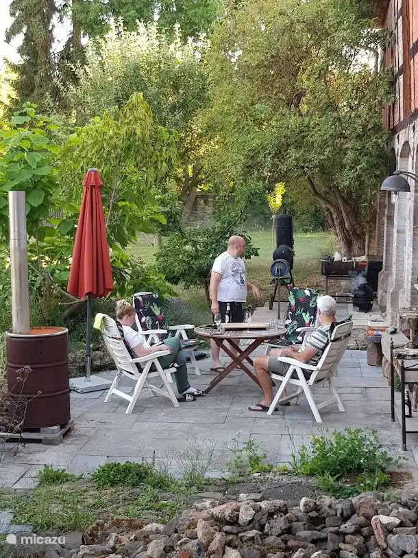 Die Terrasse am Haus mit Grill und Smoker. Ein gemütlicher Ort, um das Leben mit Freunden zu feiern.