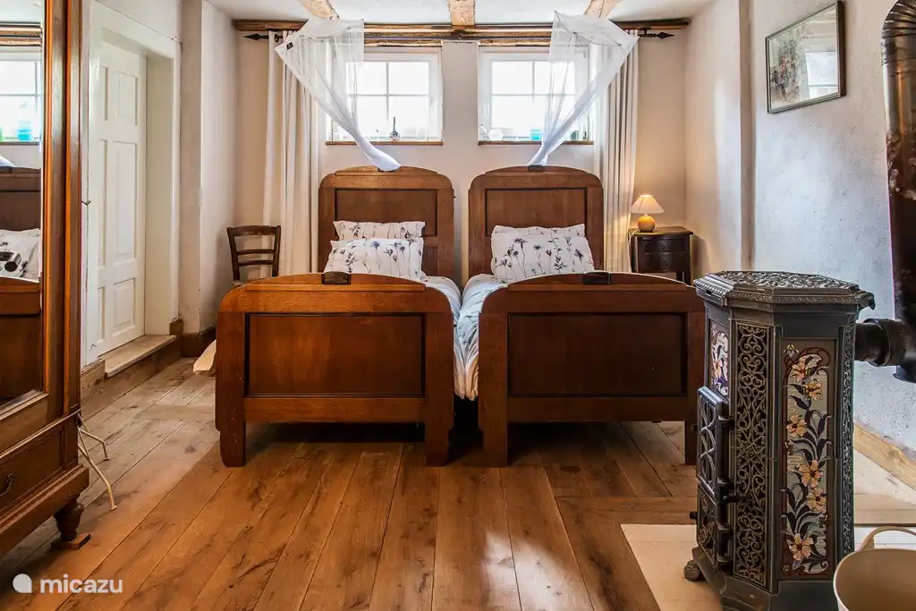 Schlafzimmer 2 mit Herd, dieses hat auch zwei bequeme Betten, und Zugangstür zum großen Badezimmer mit Dusche, WC und Waschbecken. Auch hier finden sich für die kalte Jahreszeit Zustellbetten und Wolldecken im Schrank.