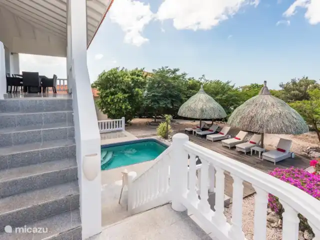 Kavel 15 coral estate rif st.marie huren in Curaçao, Banda Abou (west), Coral Estate, Rif St.Marie - villa De trap van de 1e etage naar de begane grond buitenom. Zo kom je op de terrassen en in de tuin en bij het privé zwembad. In het huis binnen is natuurlijk ook een trap om naar de slaapkamers te gaan of naar de tuin.