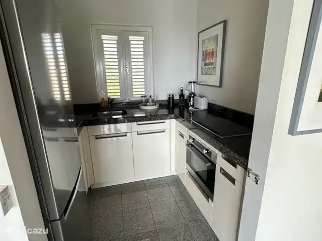 Kavel 15 coral estate rif st.marie huren in Curaçao, Banda Abou (west), Coral Estate, Rif St.Marie - villa Moderne witte keuken op de 1e etage. De keuken ligt bij de woonkamer. De keuken is voorzien van alle moderne gemakken. Het nodigt uit om een heerlijke maaltijd te bereiden.