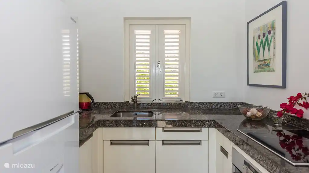 Moderne weiße Küche in der 1. Etage. Die Küche ist im Wohnzimmer. Die Küche ist mit allen modernen Annehmlichkeiten ausgestattet. Er lädt uns ein köstliches Mahl.