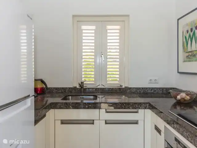 Kavel 15 coral estate rif st.marie huren in Curaçao, Banda Abou (west), Coral Estate, Rif St.Marie - villa Moderne witte keuken op de 1e etage. De keuken ligt bij de woonkamer. De keuken is voorzien van alle moderne gemakken. Het nodigt uit om een heerlijke maaltijd te bereiden.
