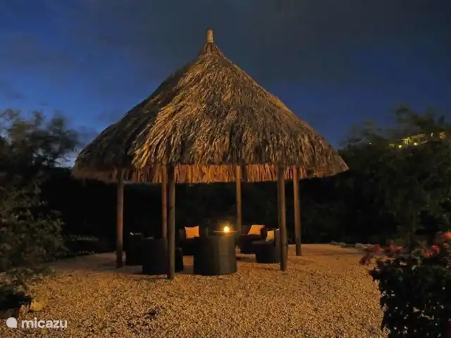 Kavel 15 coral estate rif st.marie huren in Curaçao, Banda Abou (west), Coral Estate, Rif St.Marie - villa Grote palapa achterin de tuin. Verlichting in de palapa aan en een kaarsje op tafel. Genieten op Curaçao kijkend naar de sterrenhemel.