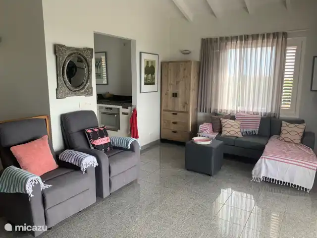 Kavel 15 coral estate rif st.marie huren in Curaçao, Banda Abou (west), Coral Estate, Rif St.Marie - villa Woonkamer met daarachter een goed geoutilleerde keuken. De keuken heeft een granieten aanrechtblad, combi-magnetron, halogeen kookplaat, vaatwasmachine, vriezer en koelkast. Een fijne, moderne plek om een heerlijke maaltijd te bereiden.