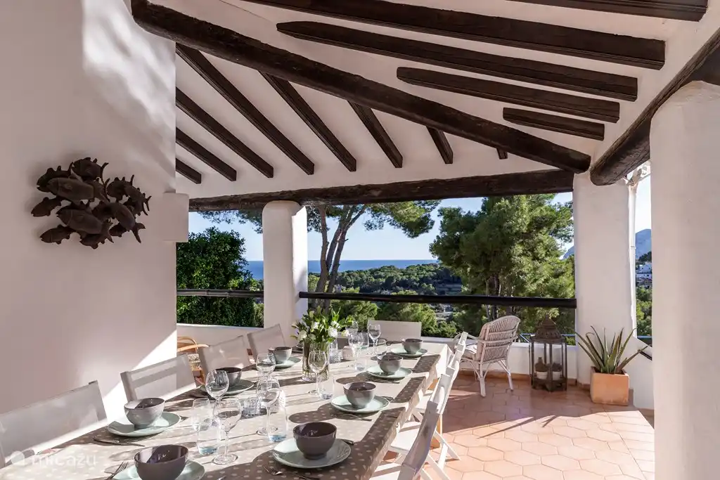 terraza cubierta con vistas a la piscina, al jardín, a la montaña y al mar.