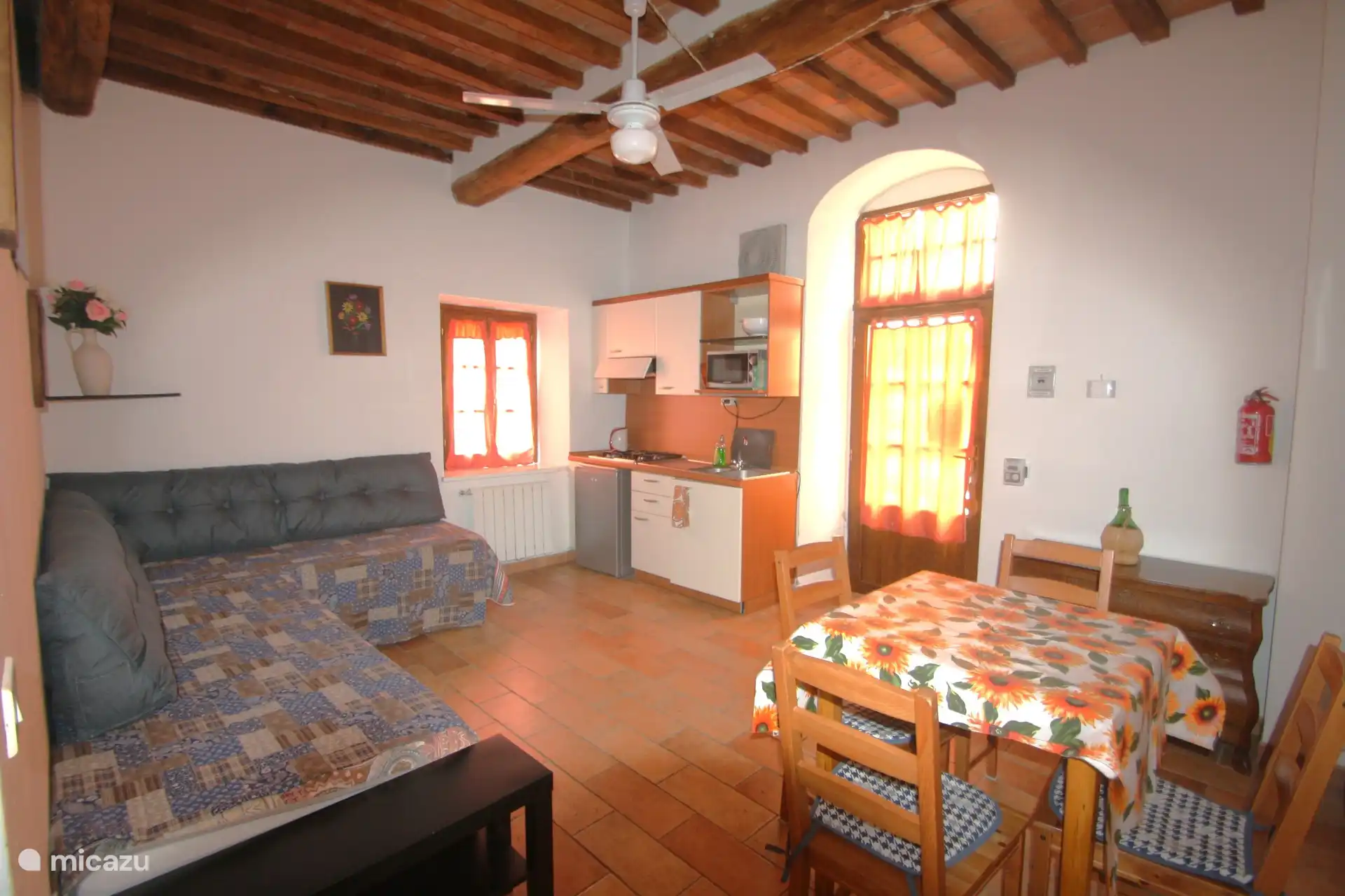 Sala de estar/cocina con 2 camas normales que también funcionan como bancos.