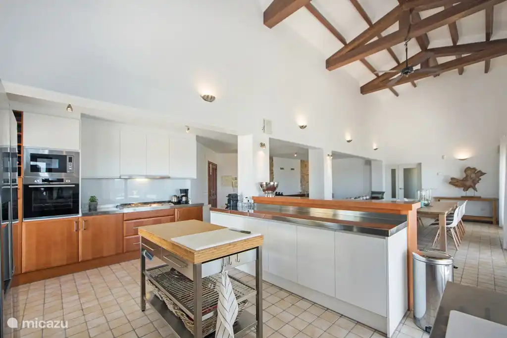 Geräumiges Wohnzimmer und offene Küche mit hohen Decken.  