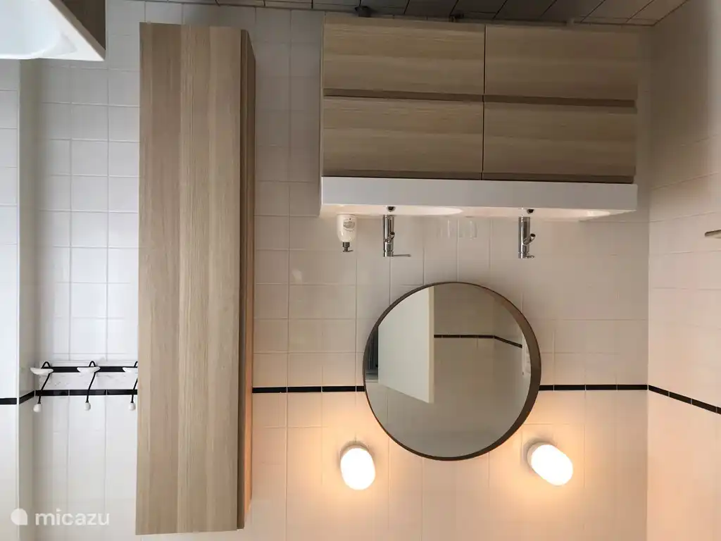 Première salle de bain au rez-de-chaussée avec WC, baignoire, douche et double vasque.