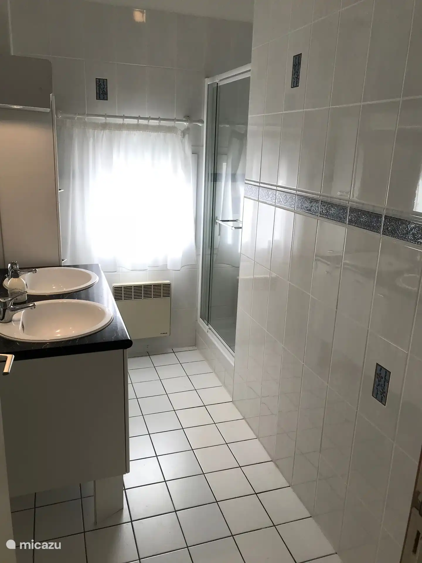 Deuxième salle de bain avec double vasque et douche au premier étage.