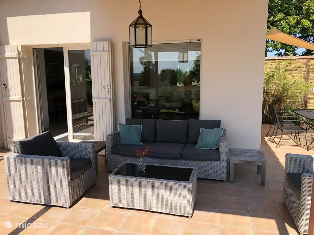 Salon luxueux installé sous la véranda.