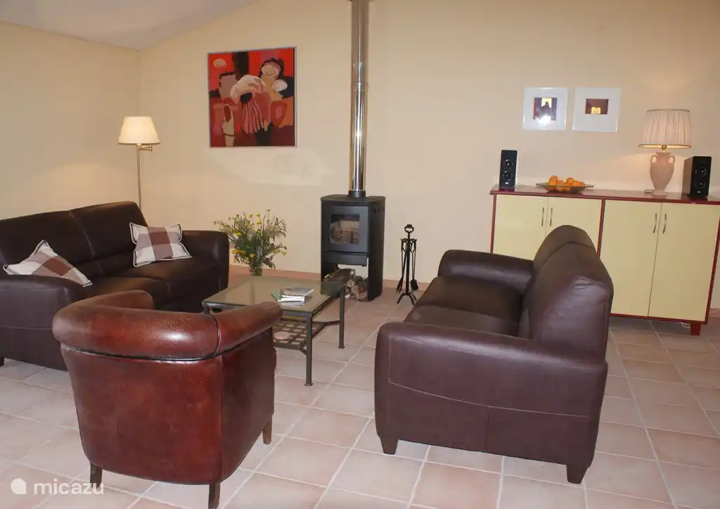 Sfeervolle ruime woonkamer met o.a. airco, TV (CanalDigitaal) en geweldige houtkachel.