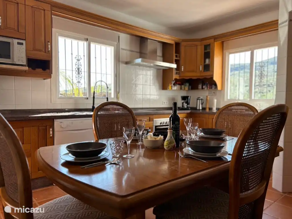 Gemütliche, geräumige Küche mit Blick auf den Garten und den Pool. Direkter Zugang zur Terrasse. 