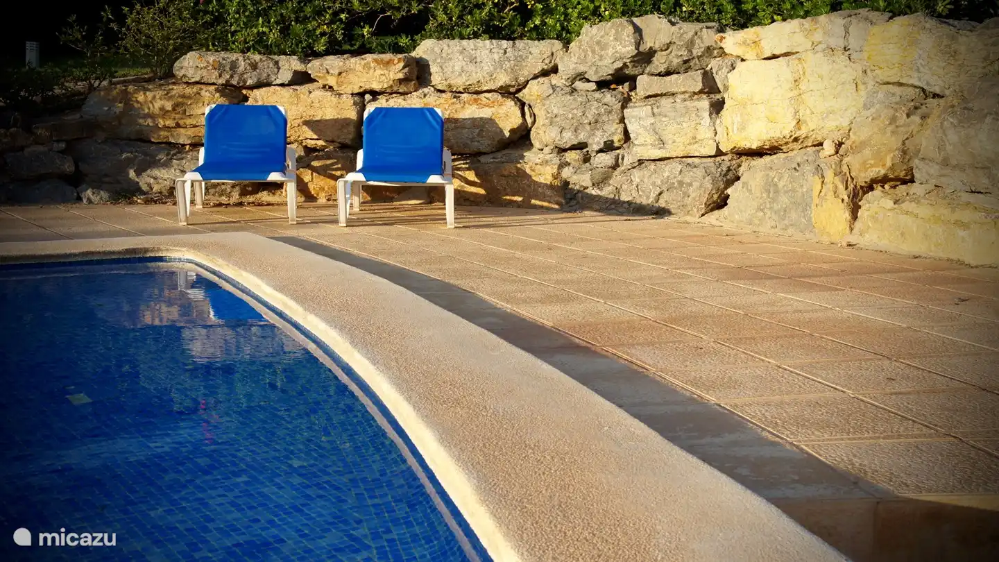 Chaises longues à disposition au bord de la piscine...