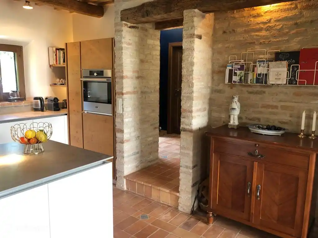 transition from the room to the kitchen and a view to the hall.