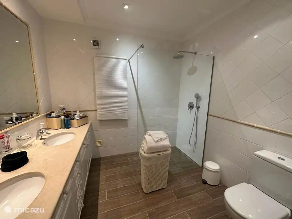 Modernes Badezimmer mit ebenerdiger Dusche und WC, das zum Hauptschlafzimmer gehört