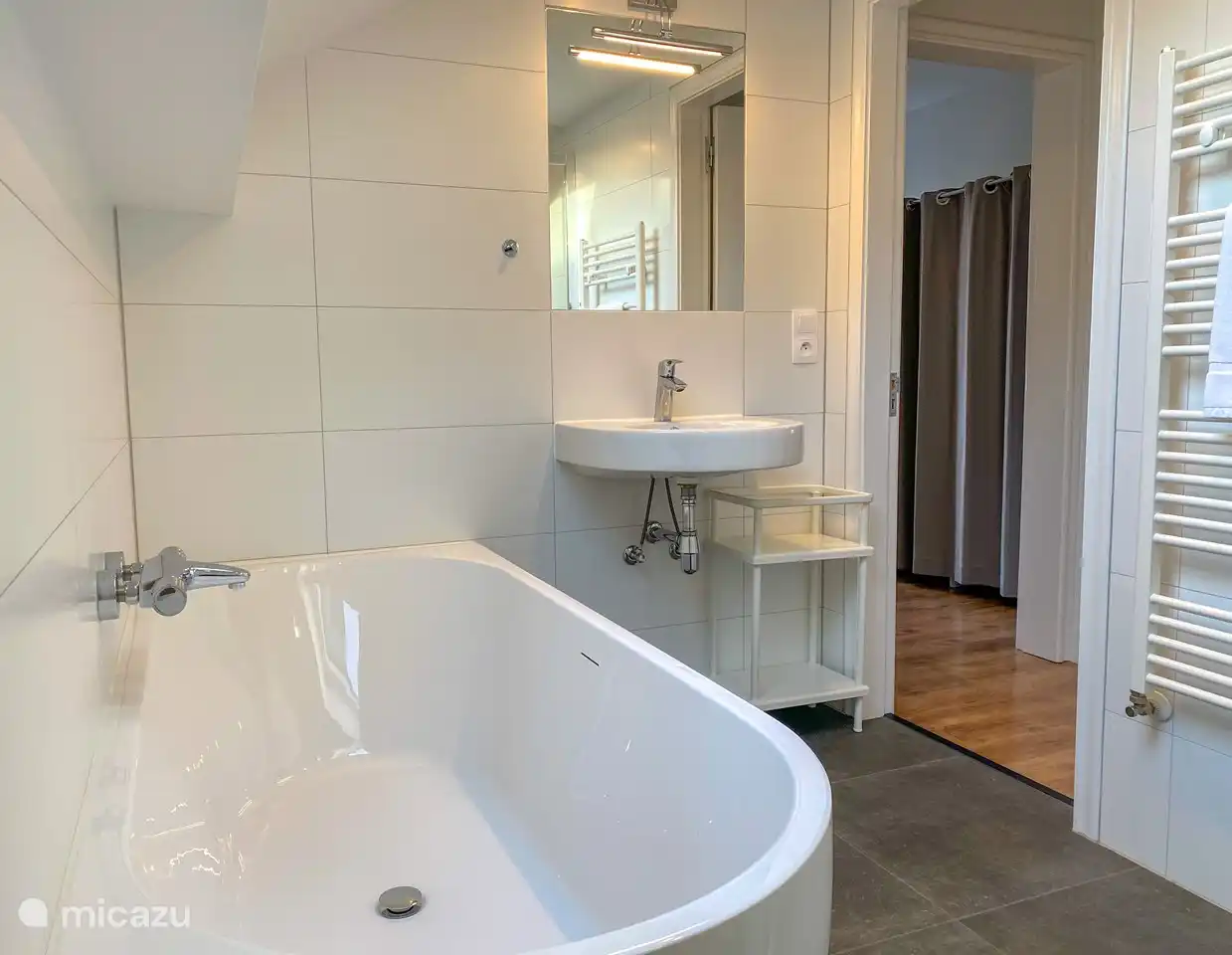 Badezimmer im ersten Stock mit Badewanne, Dusche und Toilette