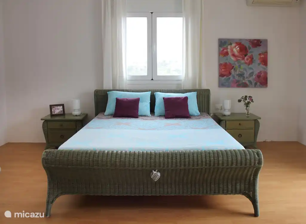 Chambre avec un lit double et balcon.