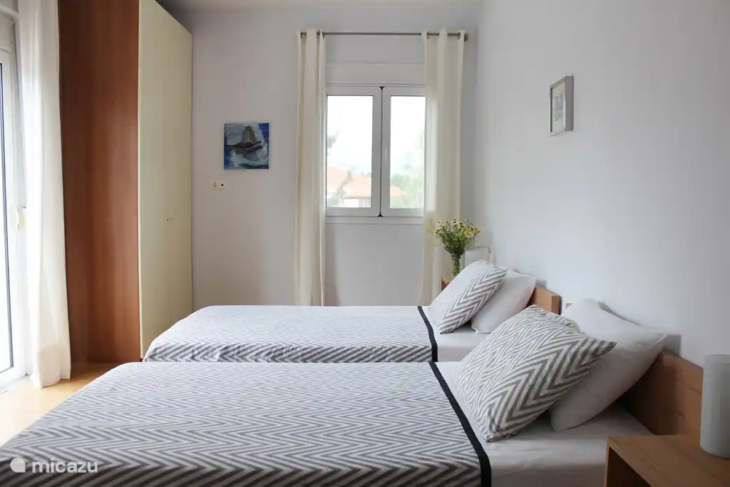 Chambre avec deux grands lits simples.