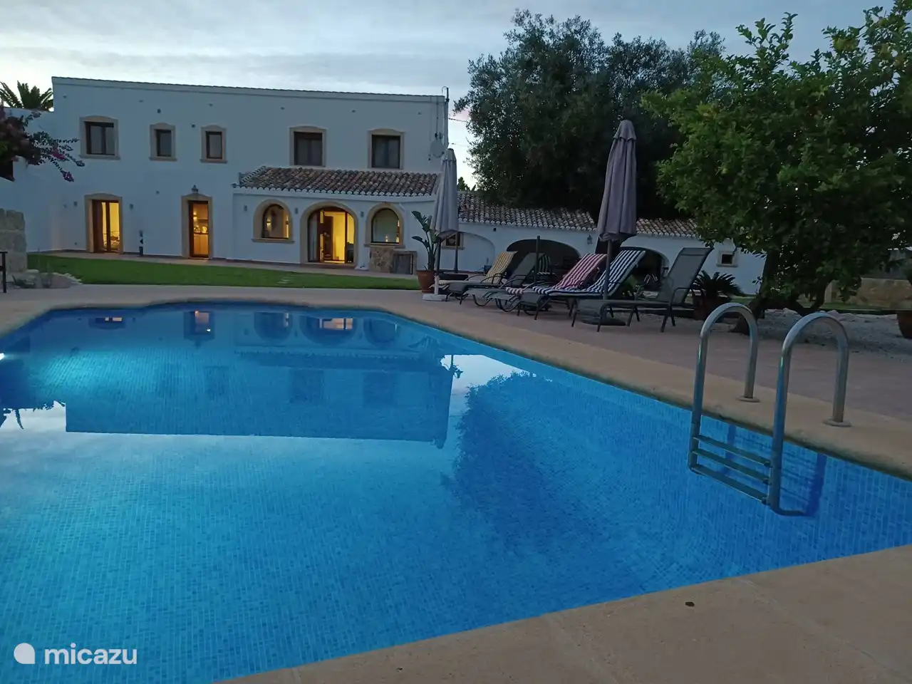 avondzicht over het zwembad naar de woning