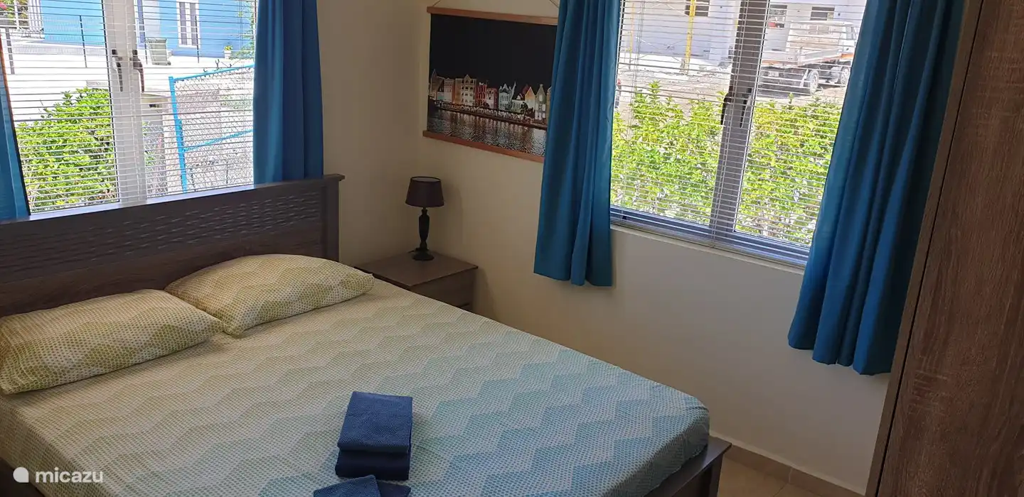 Schlafzimmer mit schönen 2 Betten. Luxaflex und Vorhänge vor den Fenstern. Geräumiger Kleiderschrank. Klimaanlage