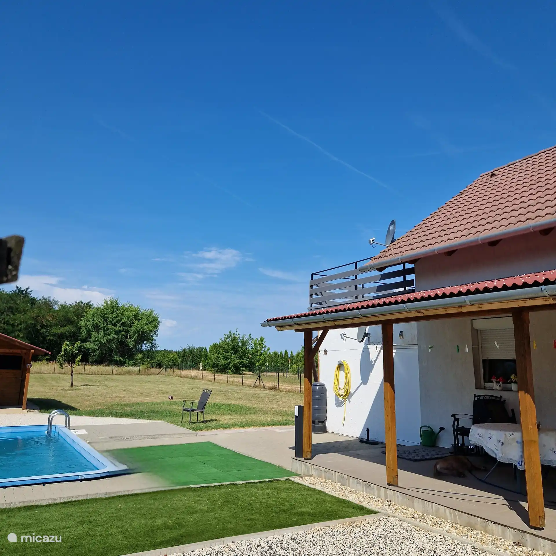 Tomada desde la esquina del jardín.
En el lado de la calle. La terraza de la azotea es del apartamento en alquiler. 