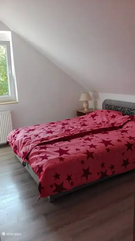 Dormitorio principal con cama doble, 2 mesitas de noche a ambos lados con lámpara, 1 armario disponible.