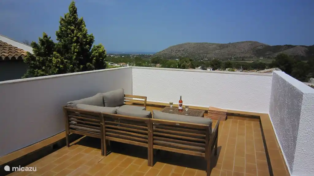 Dakterras met wijds uitzicht over de zee en bergen.