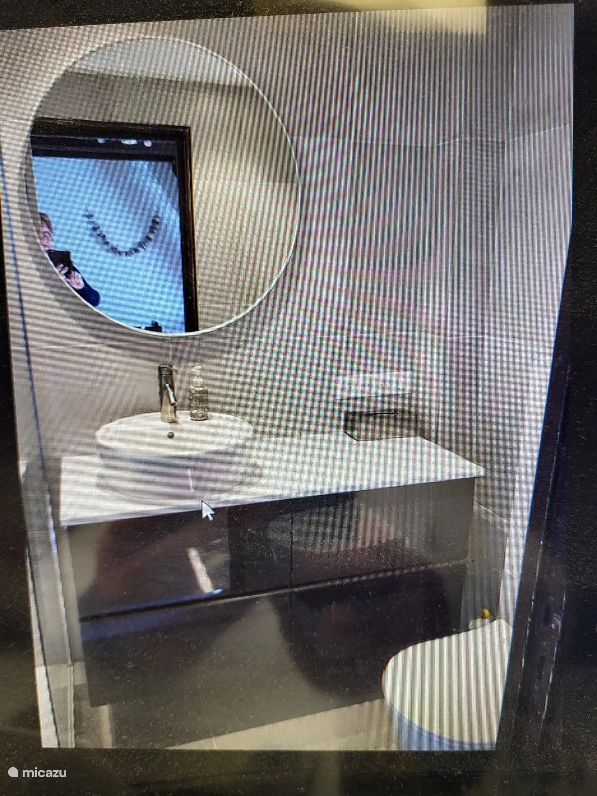 Salle de bain avec douche à l’italienne, lavabo et toilettes.