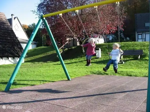 Belle aire de jeux dans le village de vacances pour les plus petits. Avec balançoire, toboggan, balançoire à bascule et balançoire.