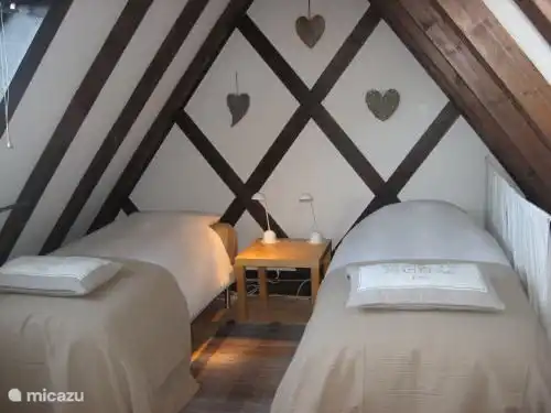 Chambre mansardée avec 2 bons lits à sommier tapissier de 80x200 (ou 160x200) par escalier et fermée par une trappe.