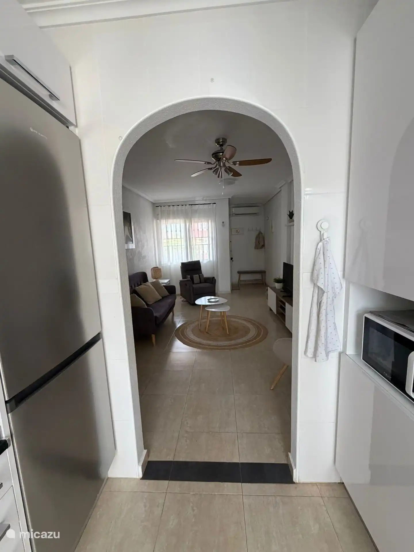 Een doorkijkje van de keuken naar de living in de ddorzonwoning met voor- en achtertuin.