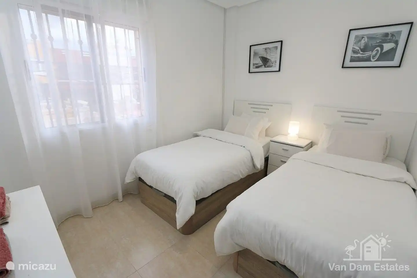 Een slaapkamer met twee éénpersoonsbedden plus ingebouwde kledingkast en ladenblok