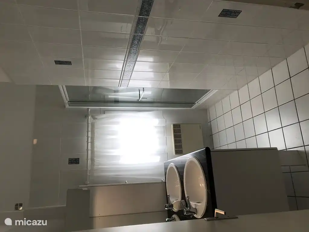 Salle de bain avec douche double vasque. Il y a des toilettes séparées sur le palier.